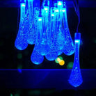 Blue garden solar lights hanging outdoors at night.