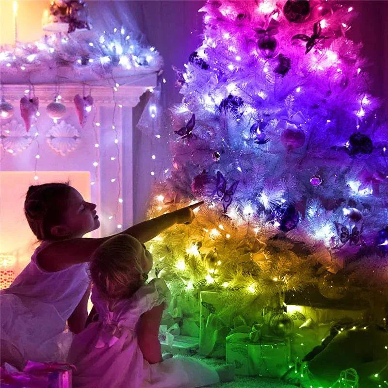 LED String Lights Christmas illuminating a decorated tree with vibrant colors and children admiring it.