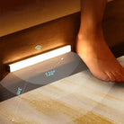 Motion sensor light wireless LED night light installed near floor, activated by foot movement.