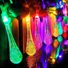 Colorful garden solar lights hanging with glowing dewdrop design, solar-powered LED bulbs, ideal for outdoor illumination.