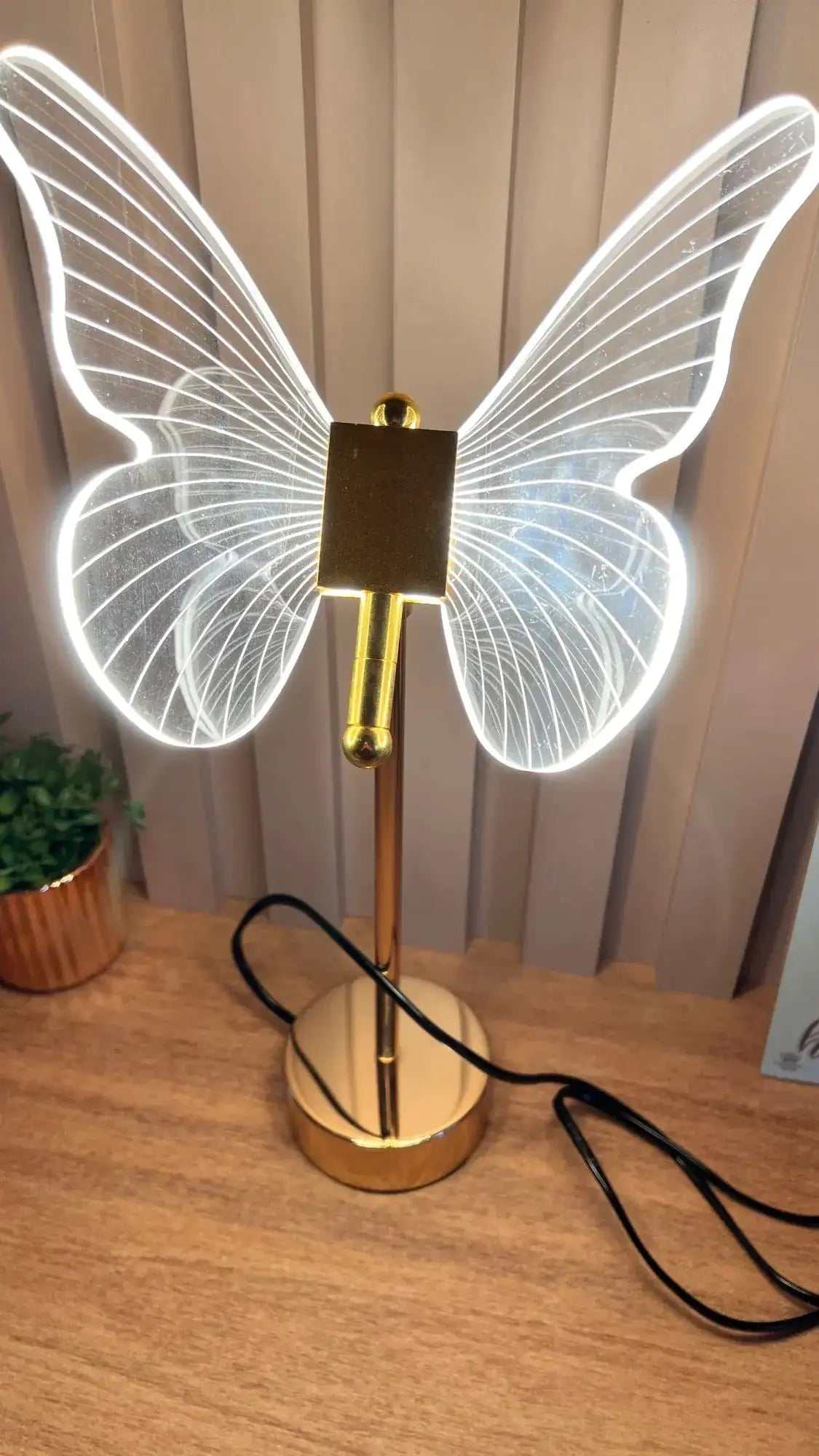 Golden Butterfly Lamp with illuminated wings on a wooden table.