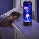 Jellyfish lamp with color-changing LED lights creating a tranquil atmosphere on a bedside table at night.