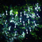 Outdoor garden illuminated by solar-powered LED dewdrop lights at night.