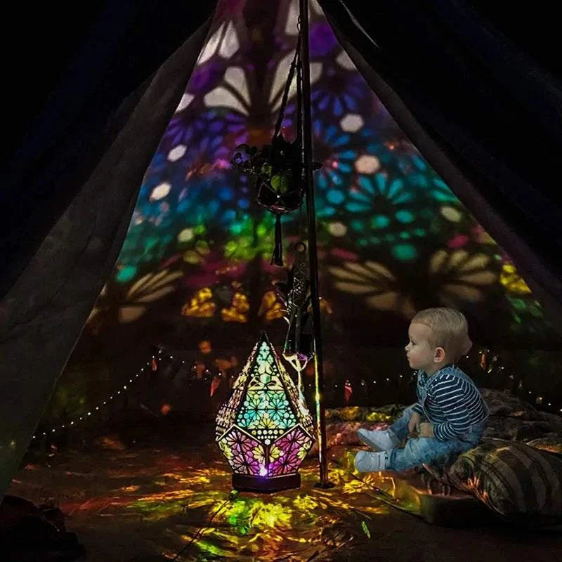 Wooden LED projection night lamp casting colorful light patterns inside a tent.